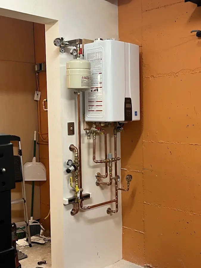 Plumbing technician inspecting water heater connections in Salmon Creek